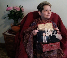 Vickie Yanagihara draped in window curtain sheers with Kuni's candle box and photo of her late husband. PORTRAIT  BY ANN HAUPRICH.
